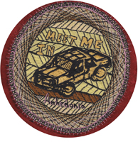This is an embroider of a car that looks like it was a block print, with the text "Meet me in Anhedonia